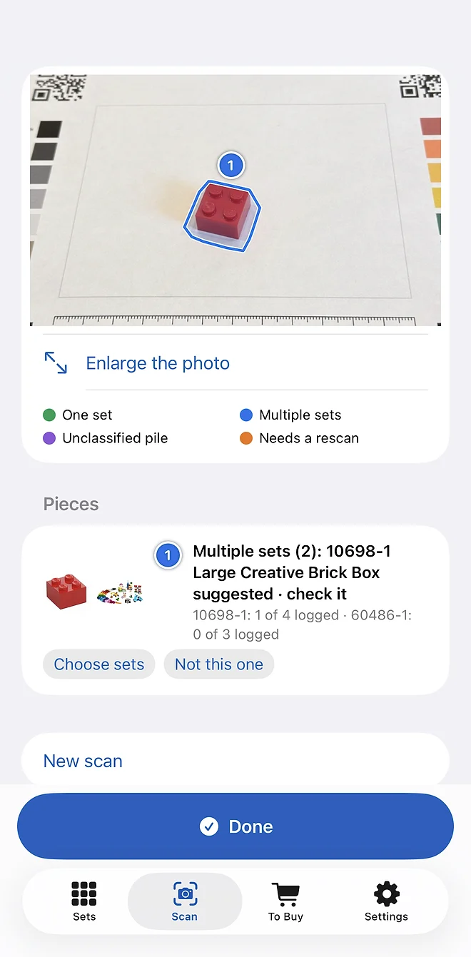 A scan's result: a red 2 × 2 brick on the sorting sheet, outlined and numbered, matched to two of the library's sets.